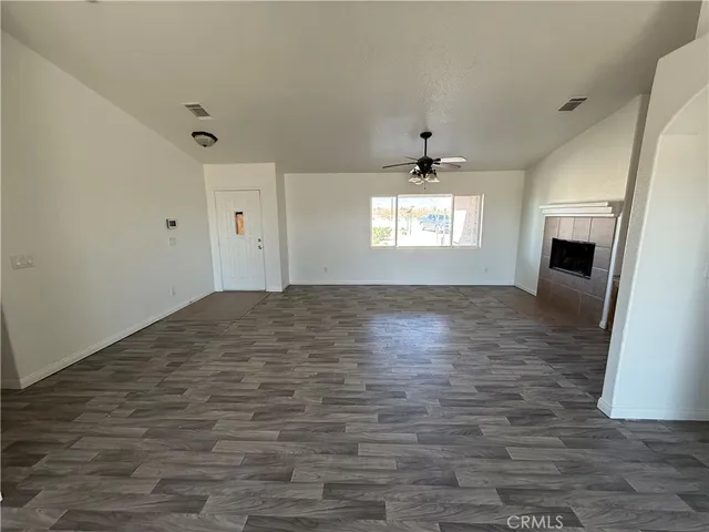 an empty room with windows and fireplace