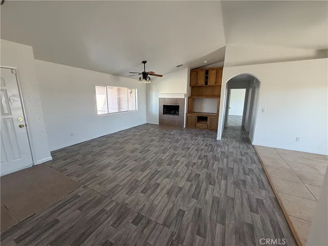 a view of empty room with wooden floor and window