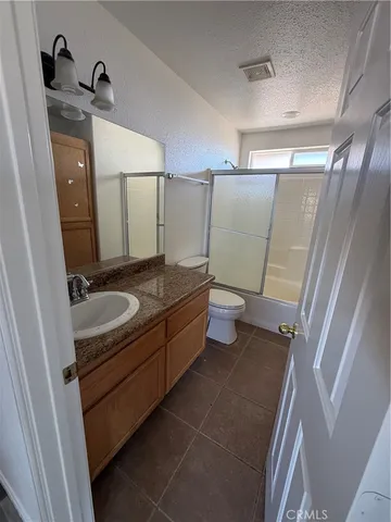 a bathroom with a granite countertop sink a mirror and a bathtub
