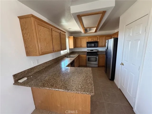 a kitchen with stainless steel appliances granite countertop a sink a stove and a refrigerator