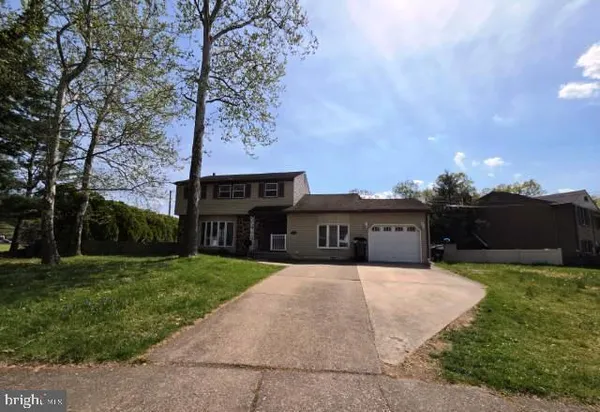 a front view of a house with yard and trees