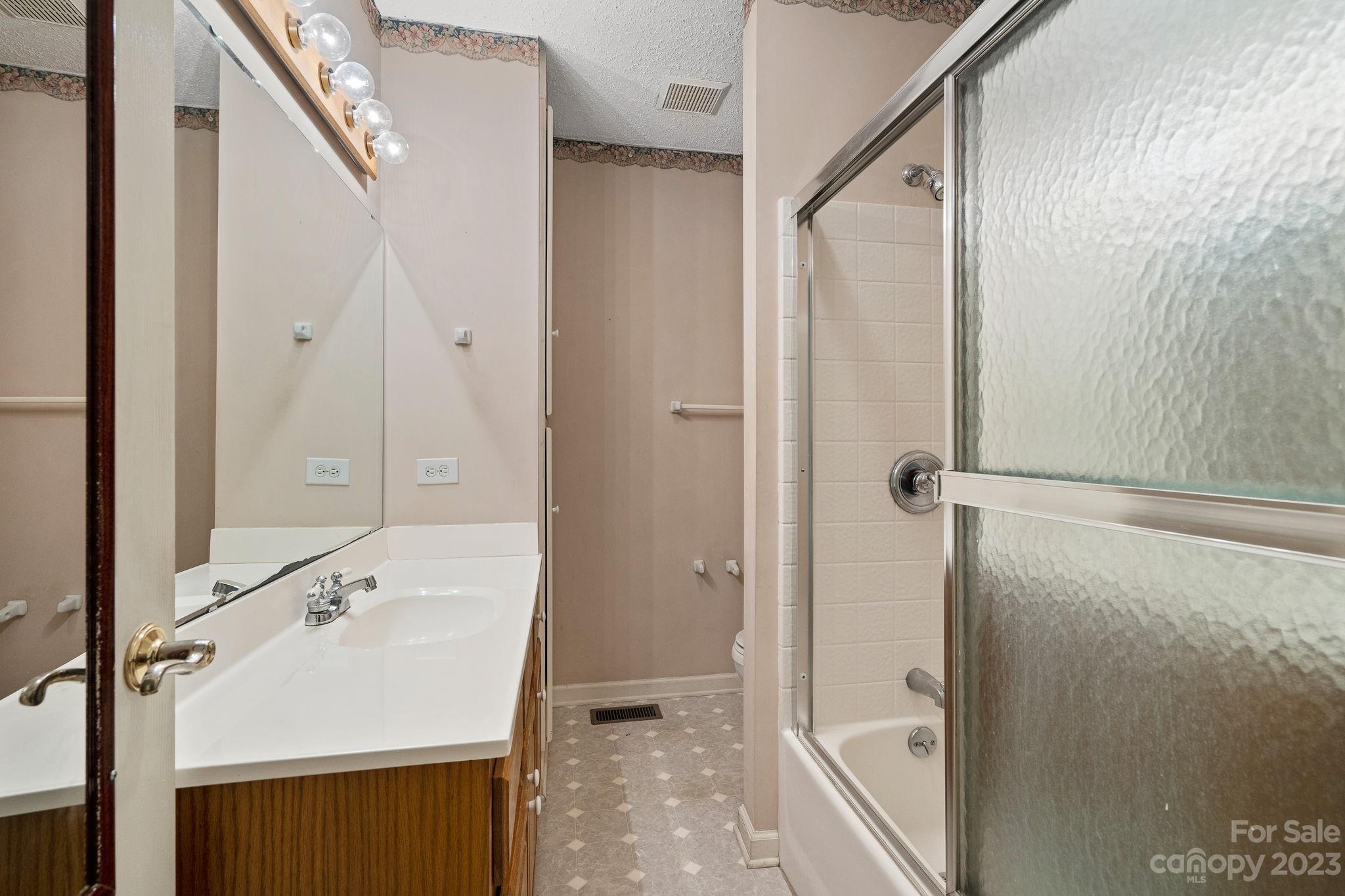 2722 Toddville Road Charlotte, NC 28214 - Photo 22 of 35 a bathroom with a sink a mirror and a shower
