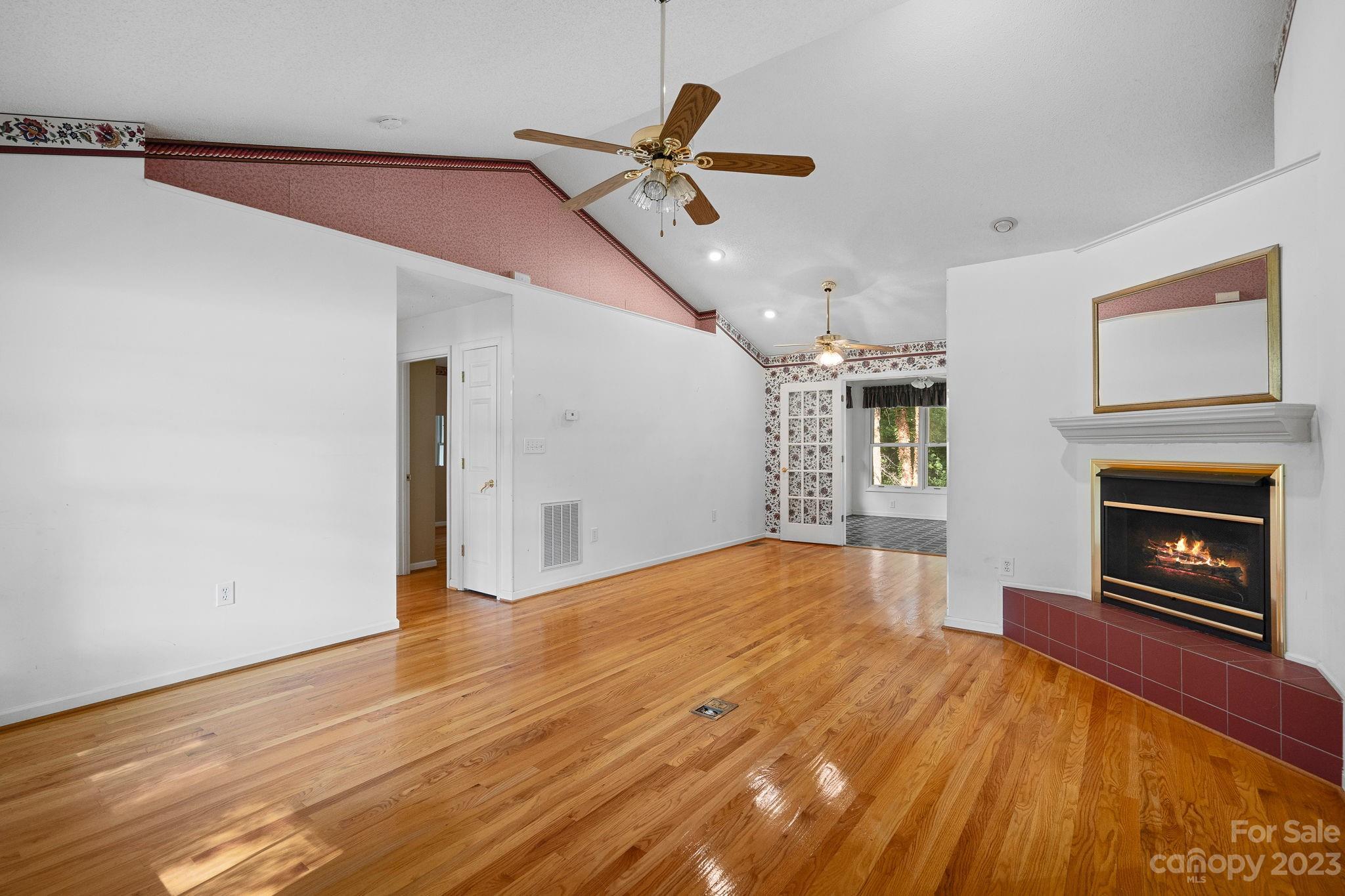 2722 Toddville Road Charlotte, NC 28214 - Photo 3 of 35 a view of empty room with wooden floor and fireplace