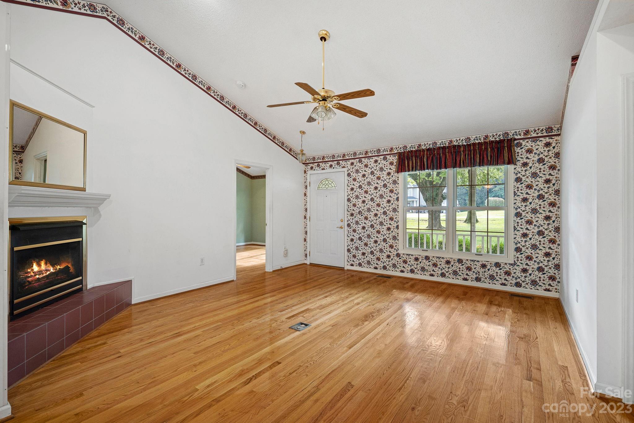 2722 Toddville Road Charlotte, NC 28214 - Photo 5 of 35 a view of an empty room with wooden floor fireplace and a window