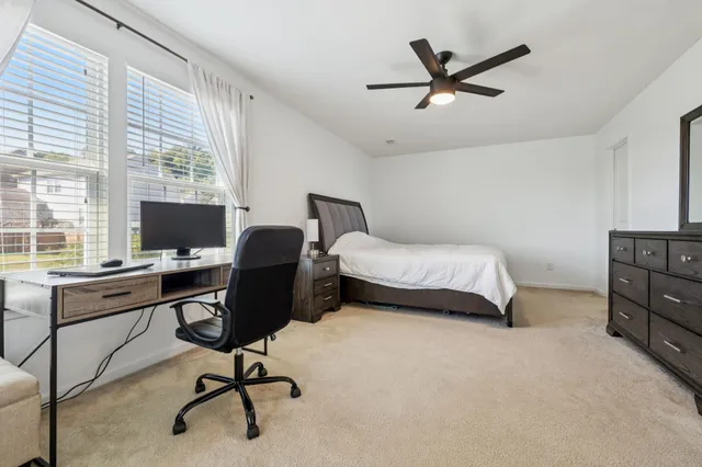 a view of a workspace with furniture and a window