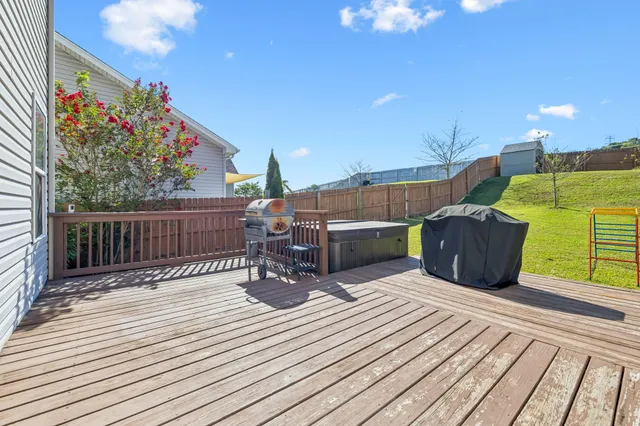 a view of a house with wooden fence and a large tree