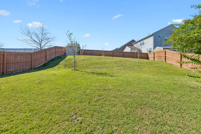 a backyard of a house with wooden floor and outdoor seating