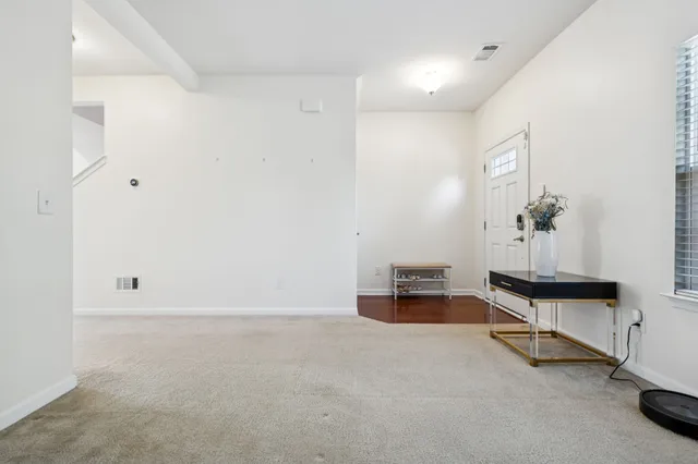 a living room with furniture and a flat screen tv with kitchen appliances