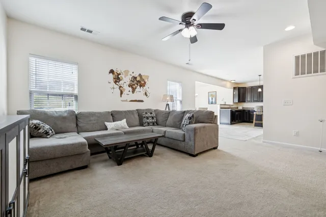 a open kitchen with stainless steel appliances kitchen island granite countertop a table chairs and a refrigerator