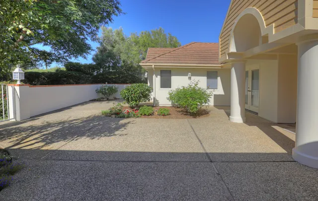 a front view of a house with a yard and potted plants
