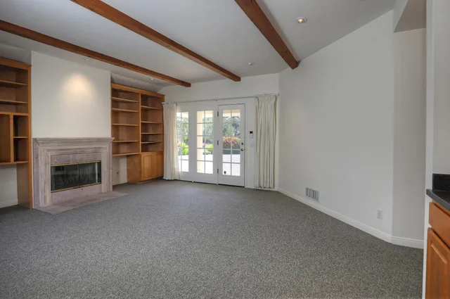 an empty room with a fireplace and window