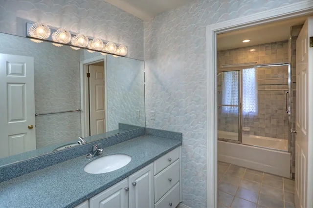 a kitchen with white cabinets and a window