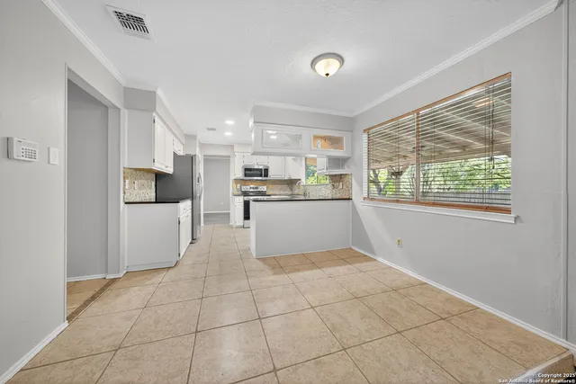 a kitchen with granite countertop a refrigerator and a stove top oven