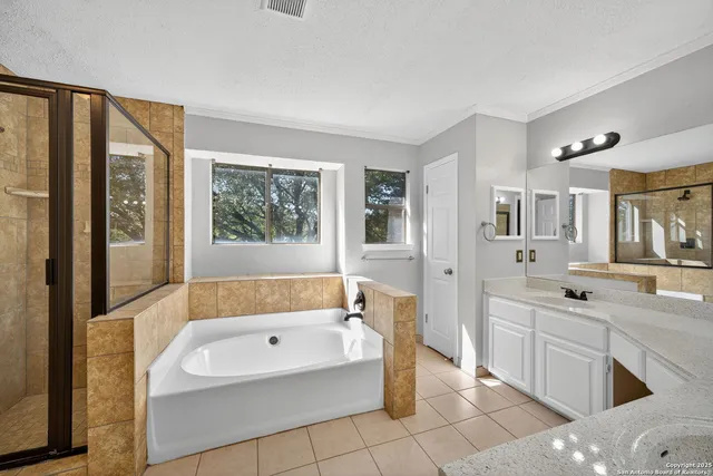 a bathroom with a tub a sink and a window
