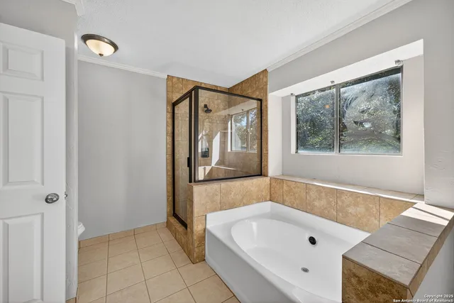 a bathroom with a tub a sink and a large mirror