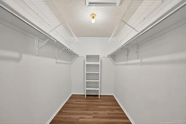 a view of a hallway with wooden floor and entryway