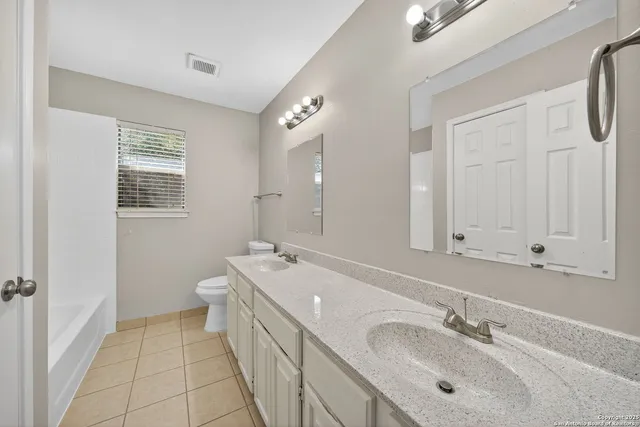 a spacious bathroom with a double vanity sink a mirror and a bathtub