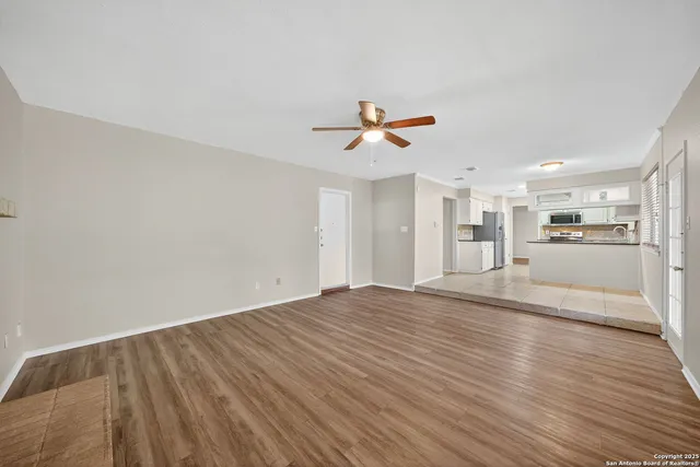 a view of empty room with wooden floor and window