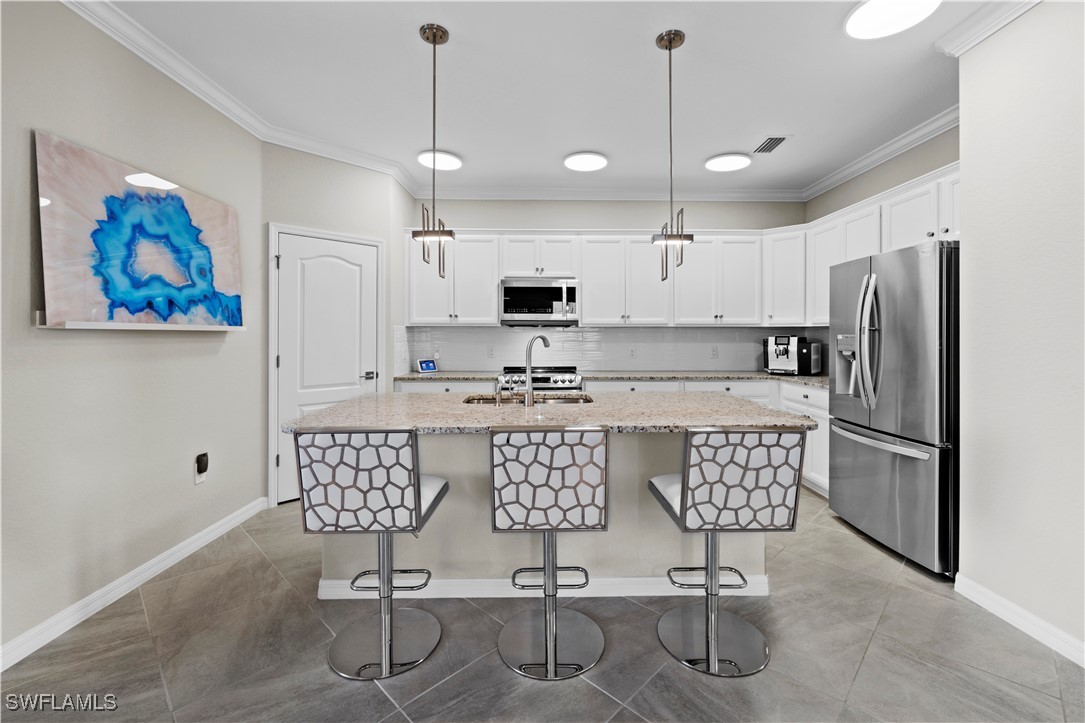 12000 Arbor Trace Drive Fort Myers, FL 33913 - Photo 14 of 50 a kitchen with stainless steel appliances granite countertop a refrigerator a stove a sink dishwasher a dining table and chairs with wooden floor