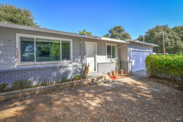 a backyard of a house with yard and outdoor seating
