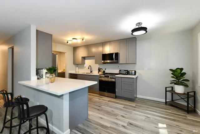a kitchen with a sink cabinets and wooden floor