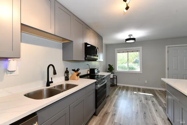 a kitchen with a sink stove top oven and refrigerator