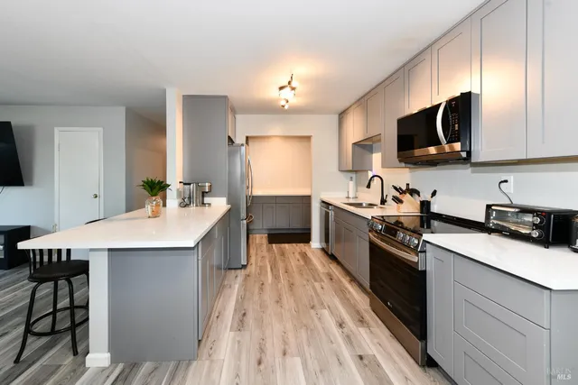 a kitchen with a sink a microwave a stove and refrigerator