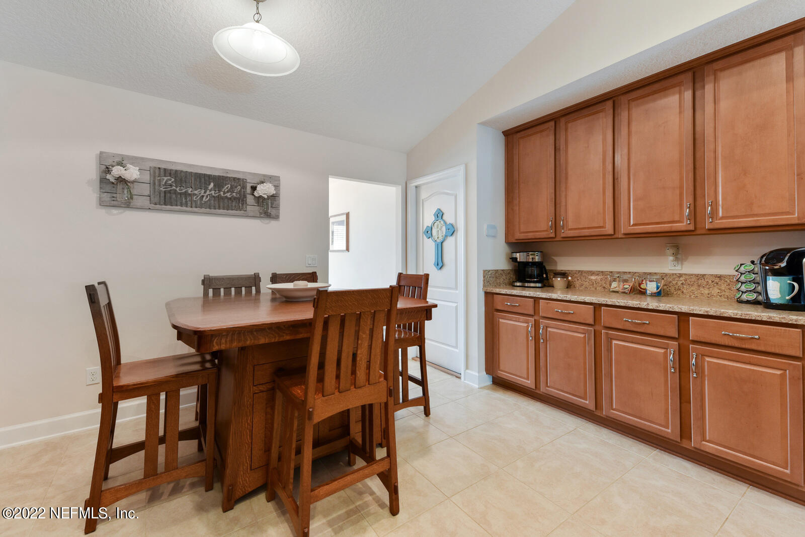 1973 Derringer Road Jacksonville, FL 32225 - Photo 11 of 25 a kitchen with a dining table chairs and white cabinets