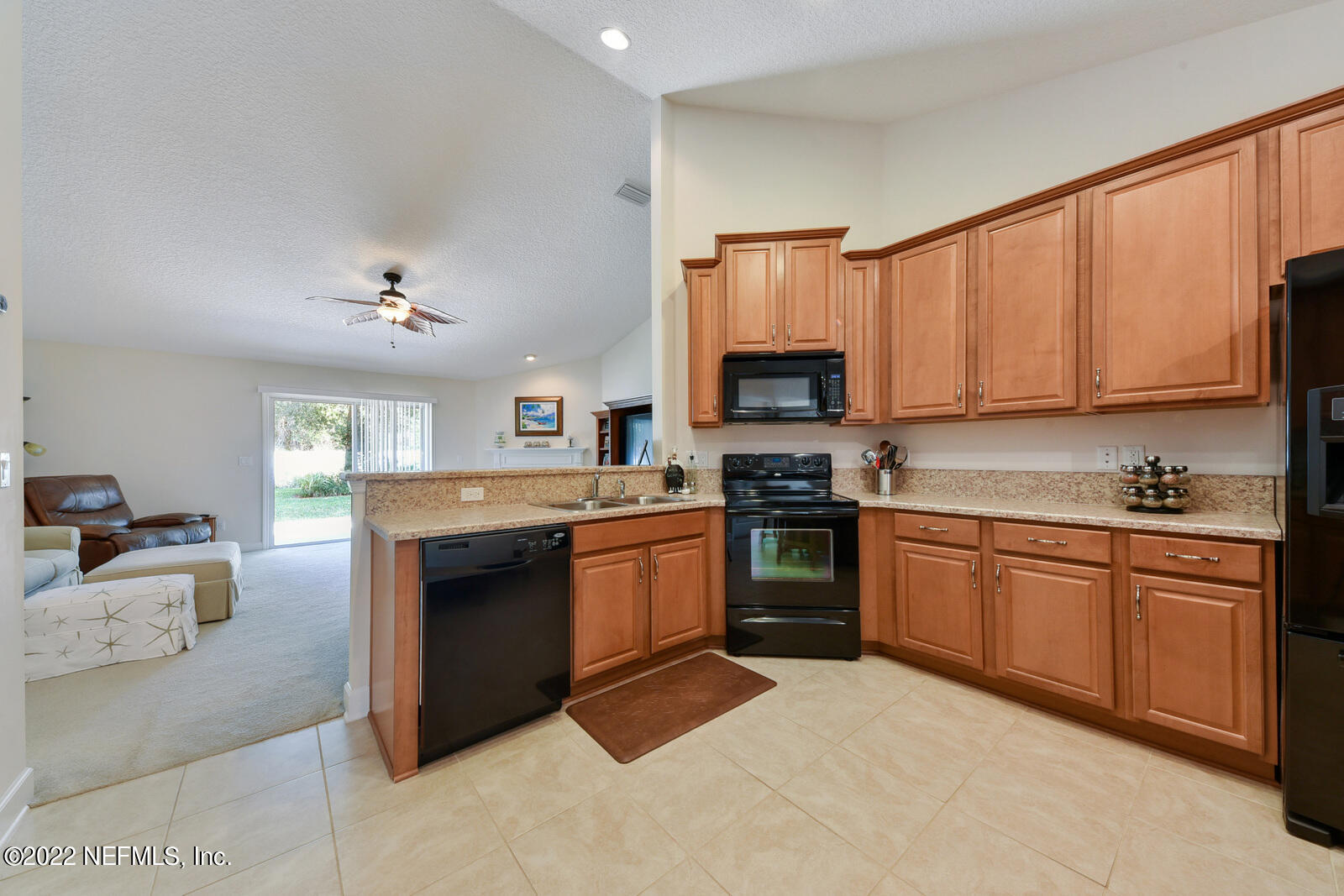 1973 Derringer Road Jacksonville, FL 32225 - Photo 12 of 25 a kitchen with granite countertop a sink cabinets stainless steel appliances and a counter space