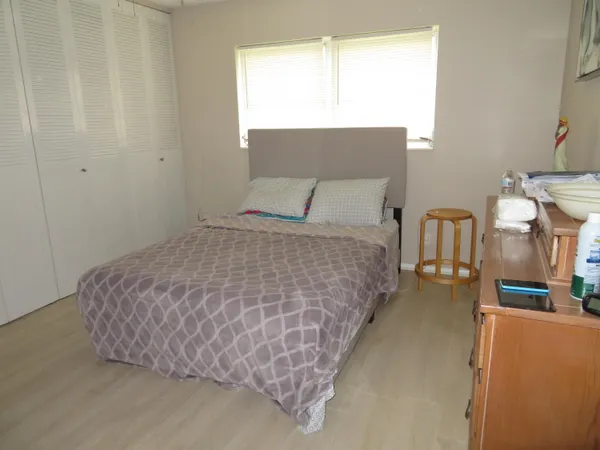 a large bed sitting in a bedroom next to a window