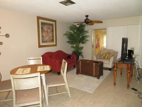 a living room with furniture a dining table and a potted plant