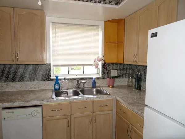 a kitchen with sink a window and cabinets