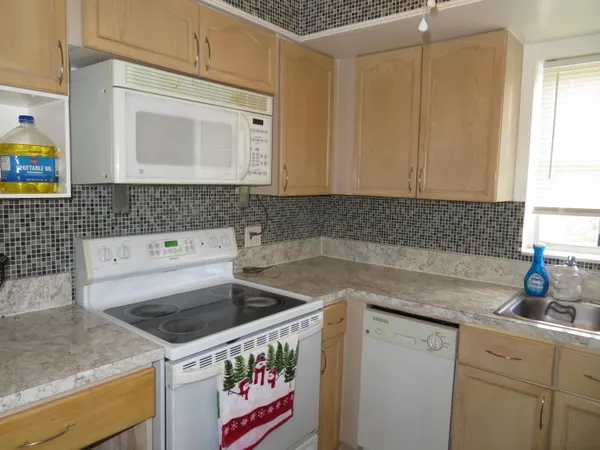 a kitchen with a sink a stove and cabinets