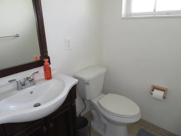 a bathroom with a sink a toilet and a mirror