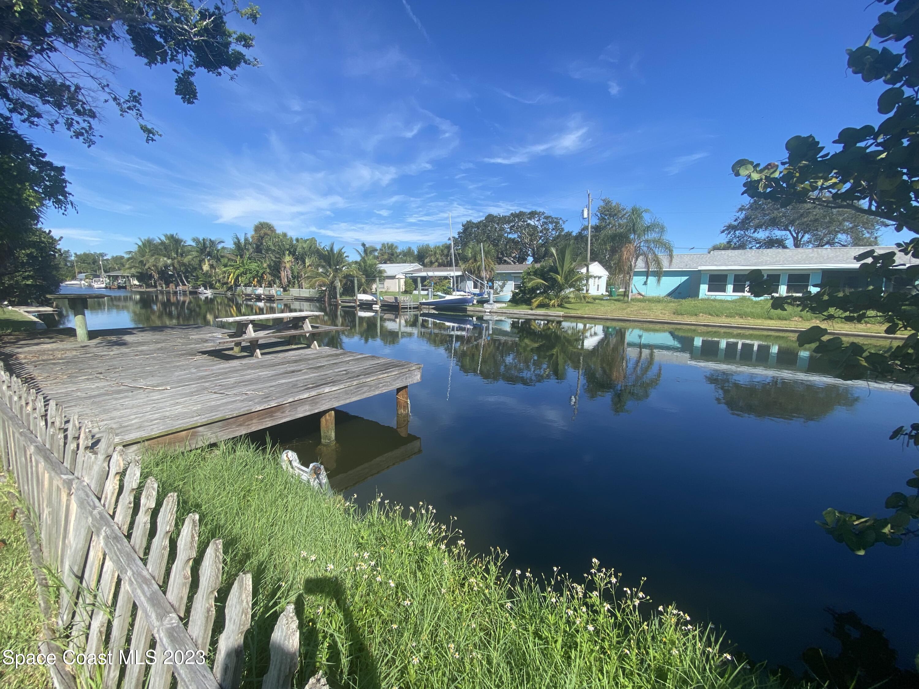 433 Blakey Boulevard Cocoa Beach, FL 32931 - Photo 12 of 15 a view of a lake with a house in the background
