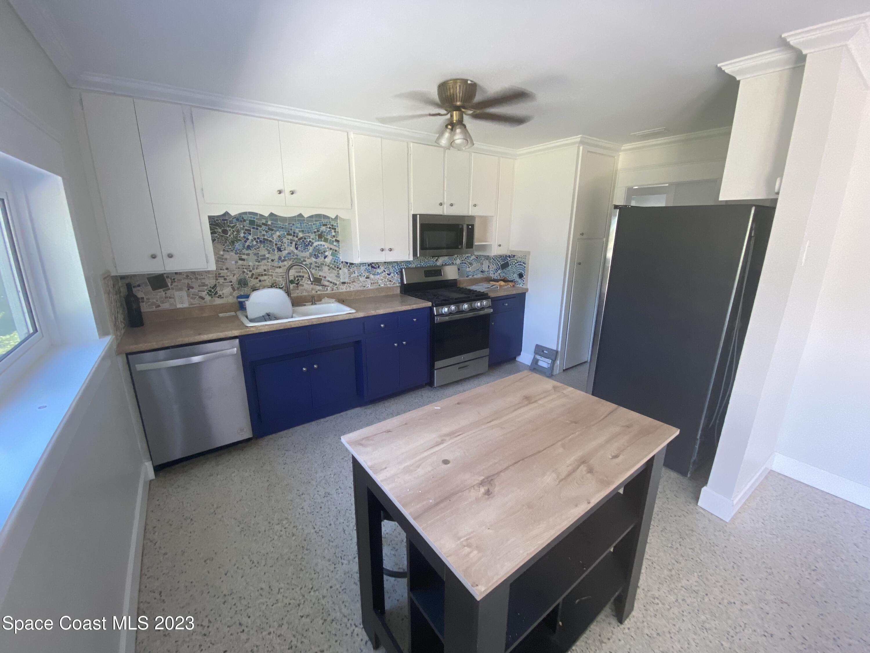 433 Blakey Boulevard Cocoa Beach, FL 32931 - Photo 5 of 15 a kitchen with stainless steel appliances a refrigerator and a stove