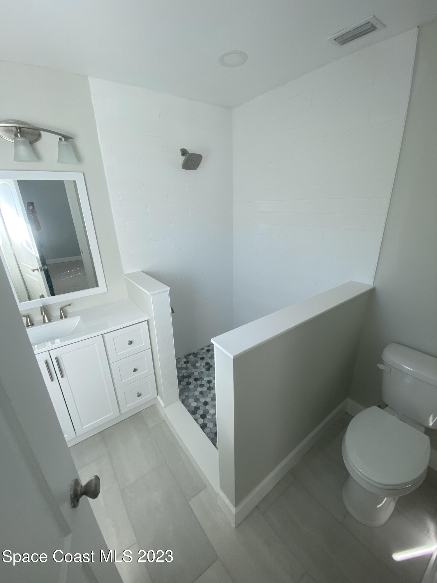 433 Blakey Boulevard Cocoa Beach, FL 32931 - Photo 8 of 15 a bathroom with a toilet sink and mirror