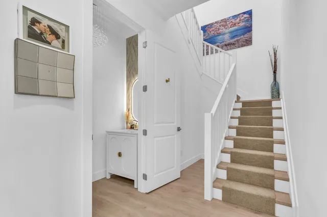 a open kitchen with stainless steel appliances granite countertop a stove a sink a dining table and chairs with wooden floor