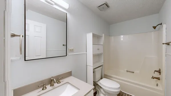 a white toilet sitting next to a bath tub