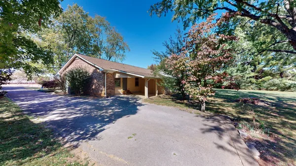 a view of a house with a yard and tree