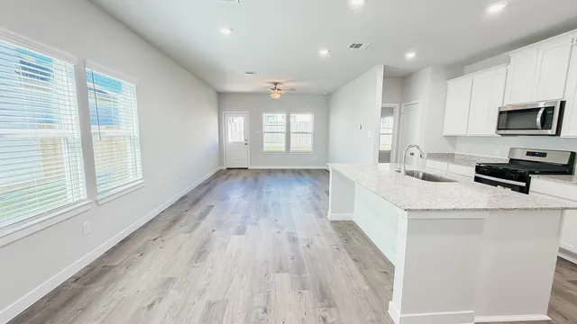 a kitchen with a wooden floor and white cabinets