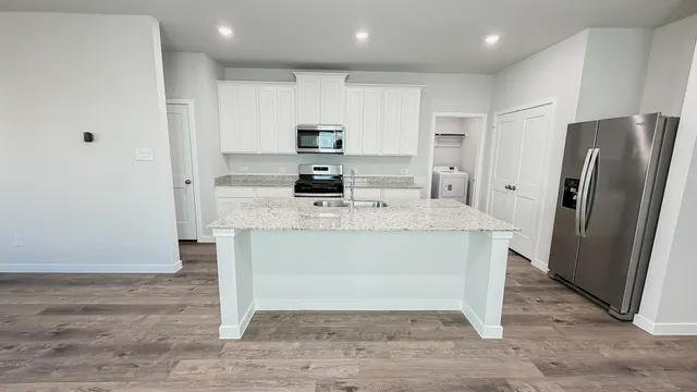 a kitchen with stainless steel appliances granite countertop a refrigerator and a stove