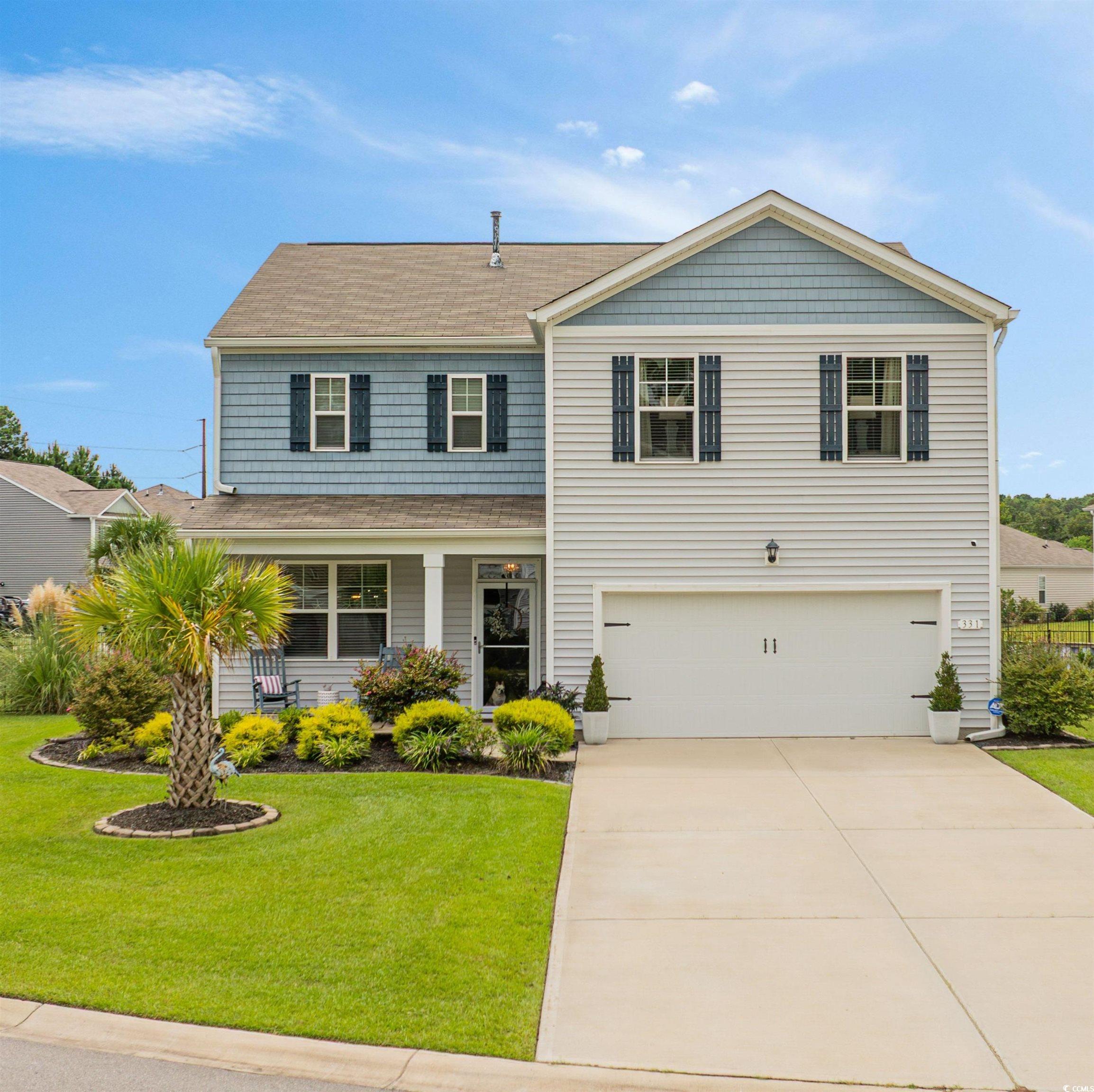 View of front of property featuring a porch and an attached garage,.