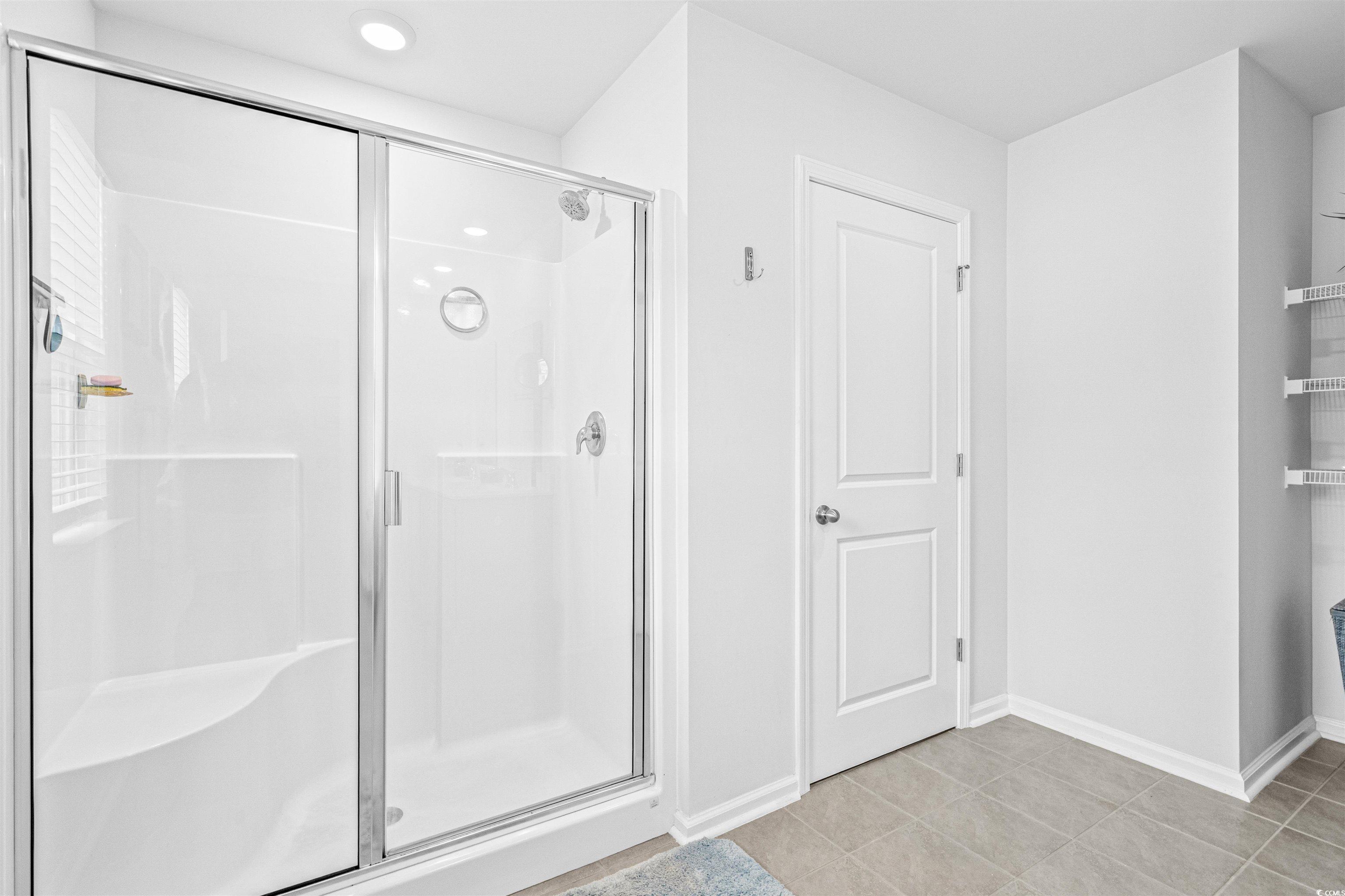 331 Emery Oak Drive Murrells Inlet, SC 29576 - Photo 21 of 32 Full bath featuring a shower stall, light tile patterned floors, and a closet