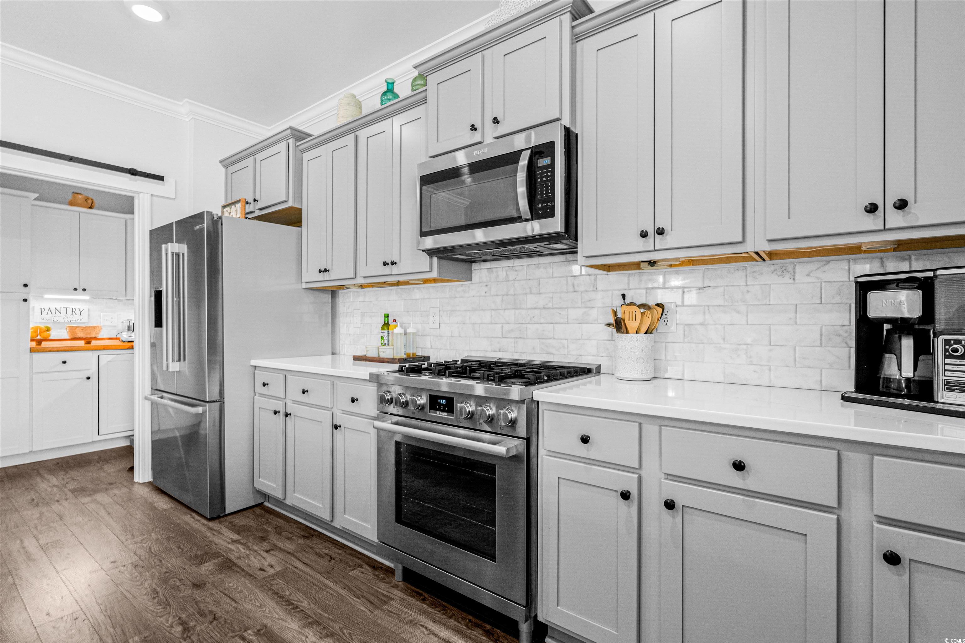 331 Emery Oak Drive Murrells Inlet, SC 29576 - Photo 7 of 32 Kitchen with marble backsplash, stainless steel appliances and quartz countertops.