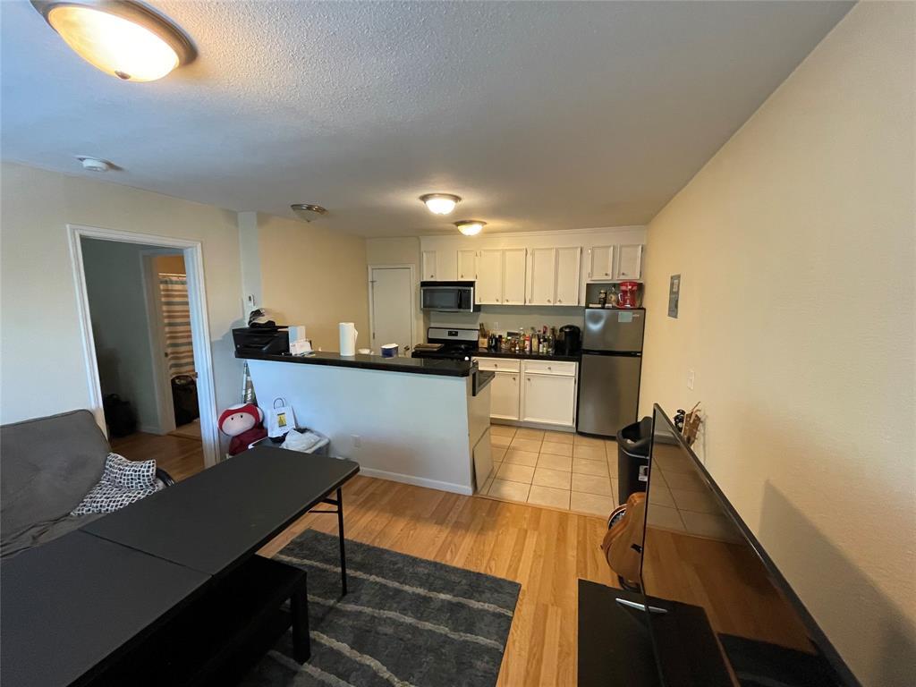 304 East 33rd Street, Unit 20 Austin, TX 78705 - Photo 2 of 12 a kitchen with a table chairs refrigerator and microwave