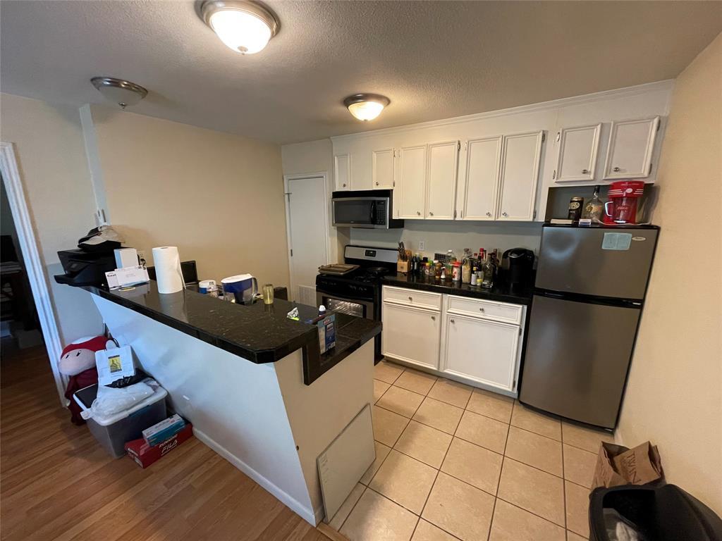 304 East 33rd Street, Unit 20 Austin, TX 78705 - Photo 3 of 12 a kitchen with stainless steel appliances a stove a sink and a refrigerator
