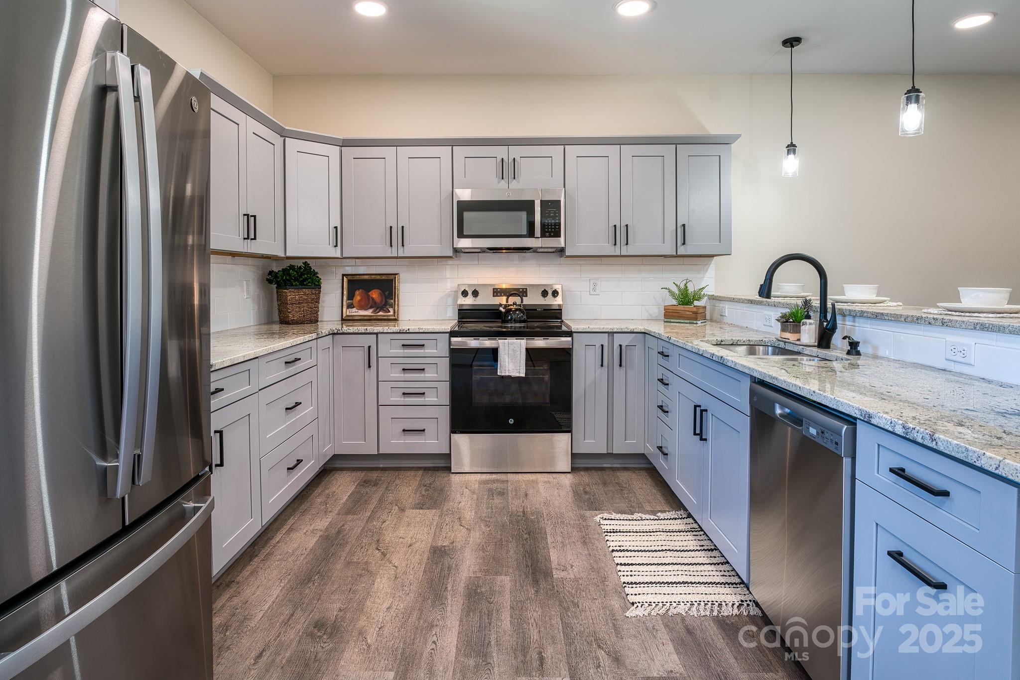 143 Carver Street, Unit 7 Brevard, NC 28712 - Photo 14 of 28 a large kitchen with stainless steel appliances granite countertop a stove a sink dishwasher and a refrigerator