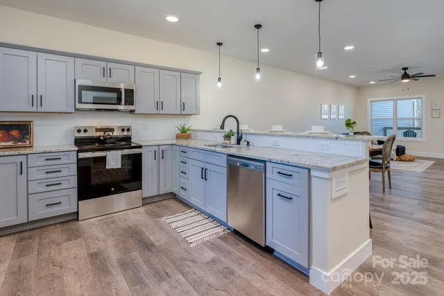 a kitchen with stainless steel appliances granite countertop a stove oven and white cabinets