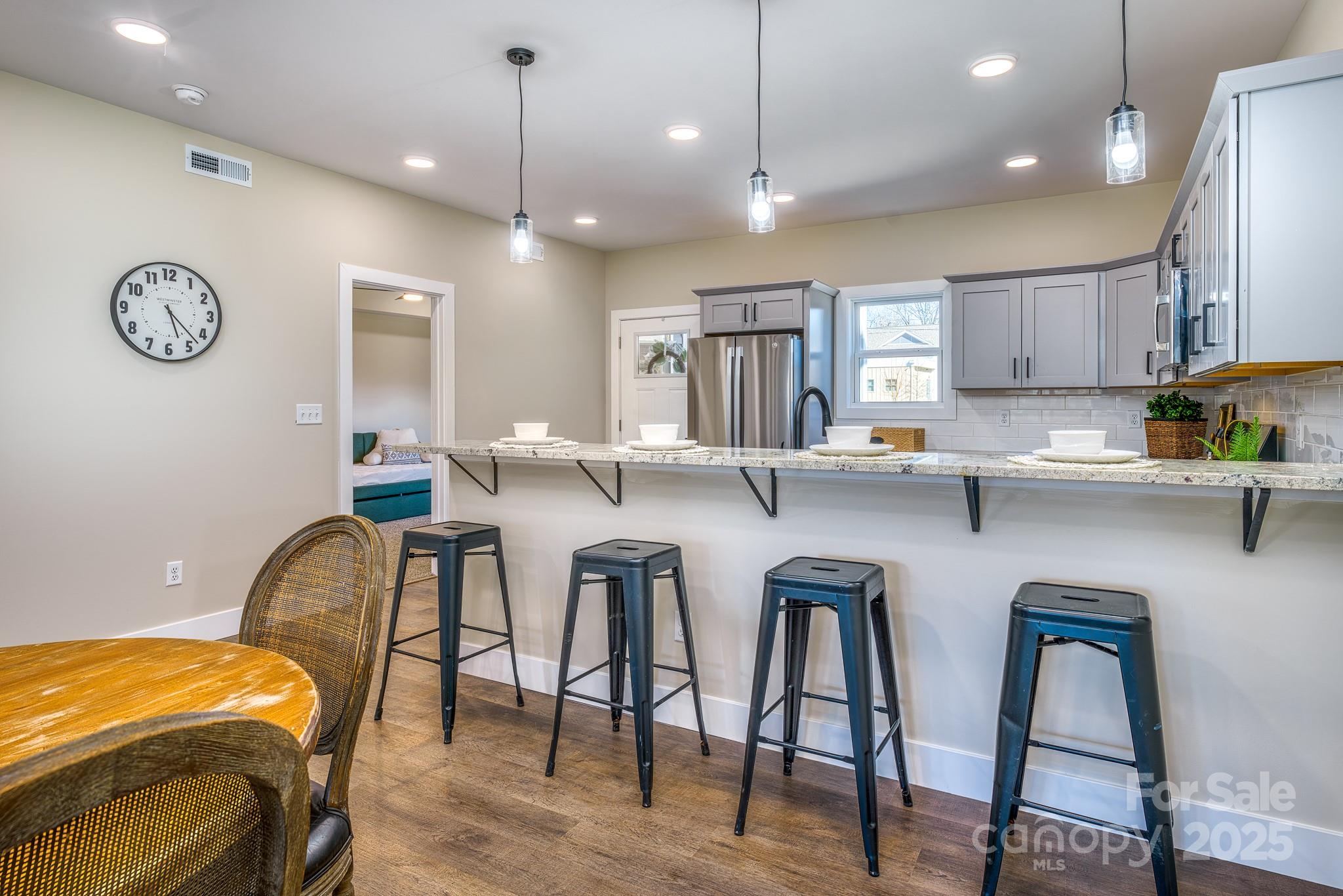 143 Carver Street, Unit 7 Brevard, NC 28712 - Photo 4 of 28 a kitchen with stainless steel appliances granite countertop a table chairs sink and window